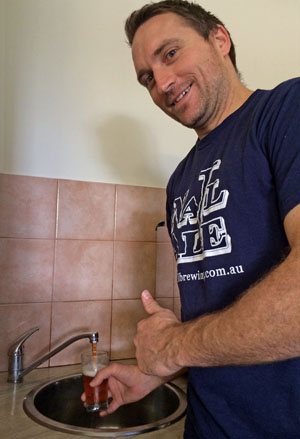 Dan Turley – Brewer at Nail Brewing pouring a sample from tap in the suburb of Bassendean. 