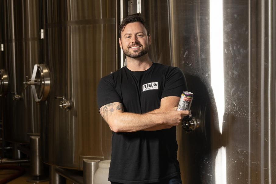 Robert Brajkovich, from Feral Brewing Co., smiling and holding a beer