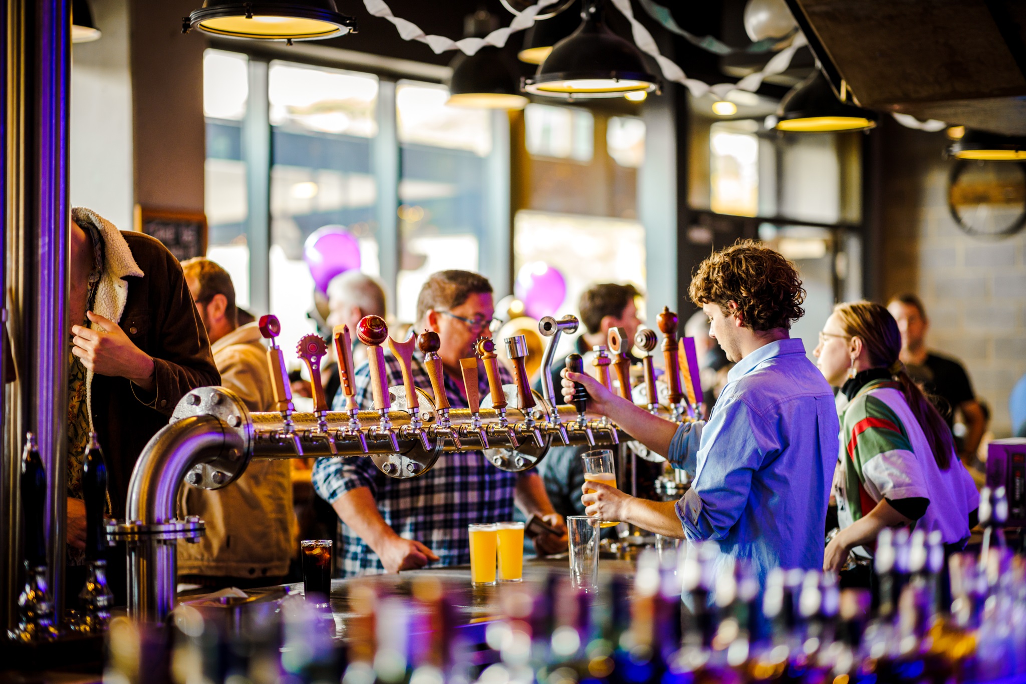 Bartenders serving beers to customers