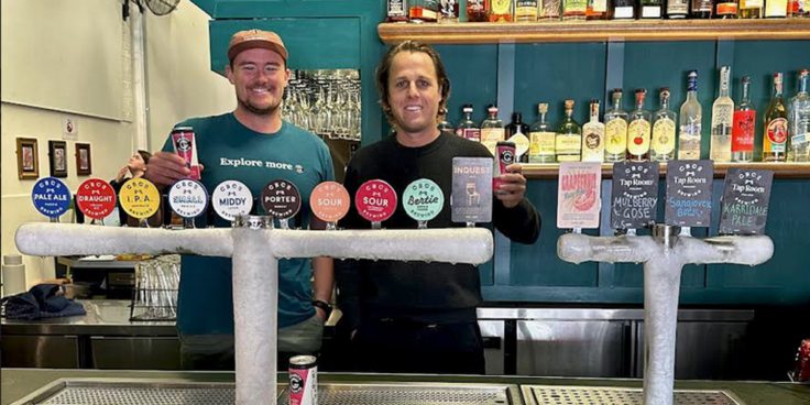 Two men from Gravity Seltzer and CBCo Brewing behind a bar