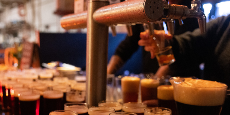 Person at beer taps pouring beer